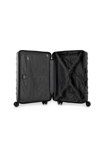 Maleta rodante de material duro y negro, que cuenta con un interior abierto con bolsillos de malla, correas en cruz y un diseño de superficie texturizada.