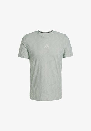 Vihreä lyhythihainen t-paita, jossa on teksturoitu aaltokuvio ja valkoinen logo rinnassa. Pyöreä pääntie, jossa on erivärinen reuna.