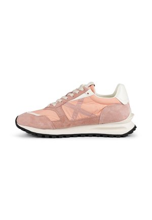 Zapatilla deportiva rosa y blanca con cordones, paneles de ante y tela, suela negra de dibujo y cuello acolchado en el talón vista de lado.