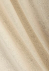 Lys beige stof med en fin, blød tekstur og diagonalt ribbet mønster, der fremhæver glatte, ensartede vævninger og subtil glans.