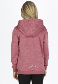 Polo tröja i heathered rosafärg, med en framtill liggande känguruficka, ribbade ärmslut och bergslogotyp på bakre fållen. Mjuk textur.