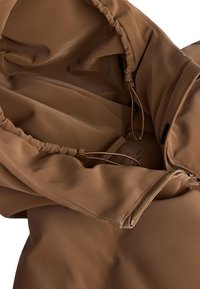 Unutrašnjost smeđeg kaputa s kapuljačom izrađena od tkanine, sa zatvaranjem na vezicu i zlatnim patentnim zatvaračem. Glatka tekstura, neutralna boja, minimalno šivanje.