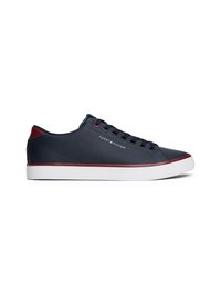 Marineblå sneakers med glat læderoverdel, rød hælkappe, hvid sål og seks sorte øjer til snørebånd. Har logo på siden.