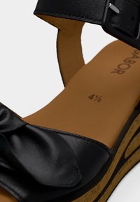 Μαύρο δερμάτινο σανδάλι με φαρδιά λουράκι και διακοσμητικό φιόγκο, υφασμένη σόλα και καφέ πάτος με ένδειξη μεγέθους 4½.