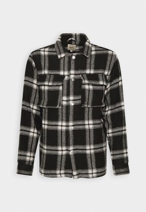Schwarz-weißer kariert gestreifter Flanellhemd mit langen Ärmeln, Knopfverschluss, zwei Fronttaschen und klassischem Kragen. Weiche Textur.