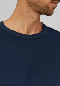 Navyblaues Rundhals-T-Shirt aus weicher Baumwolle, mit glattem Textur und sichtbaren Nähten am Kragen.