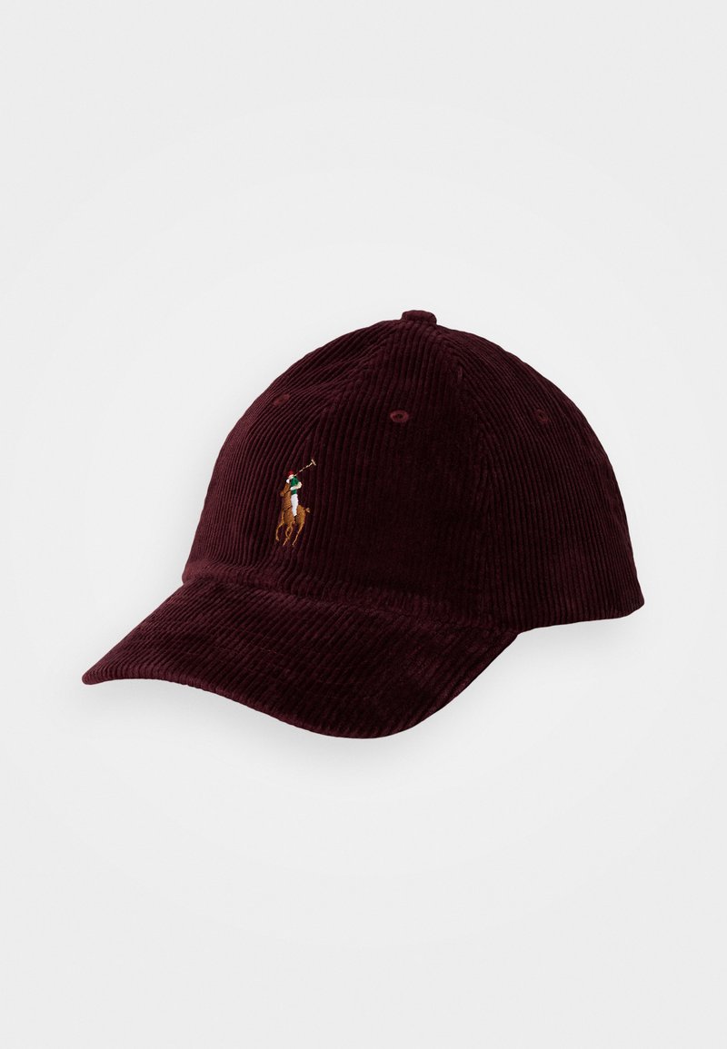 Burgunder farge kordfløyels baseball cap med buet visir og en brodert polo spiller-logo på fronten. Har teksturerte ribber og ventilasjonshull.