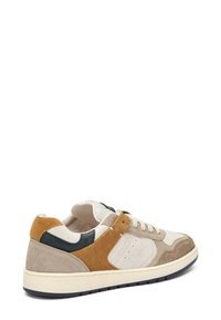 Sneakers con una combinazione di suede beige, dettagli in pelle marrone e particolari verde scuro. Punta rotonda, suola in gomma piatta e chiusura con lacci.
