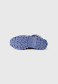 Sportschoen outsole met een gestructureerde paarse rubberen zool met een gepatroniseerde profiel voor grip en een contrasterend zwarte bovenkant.