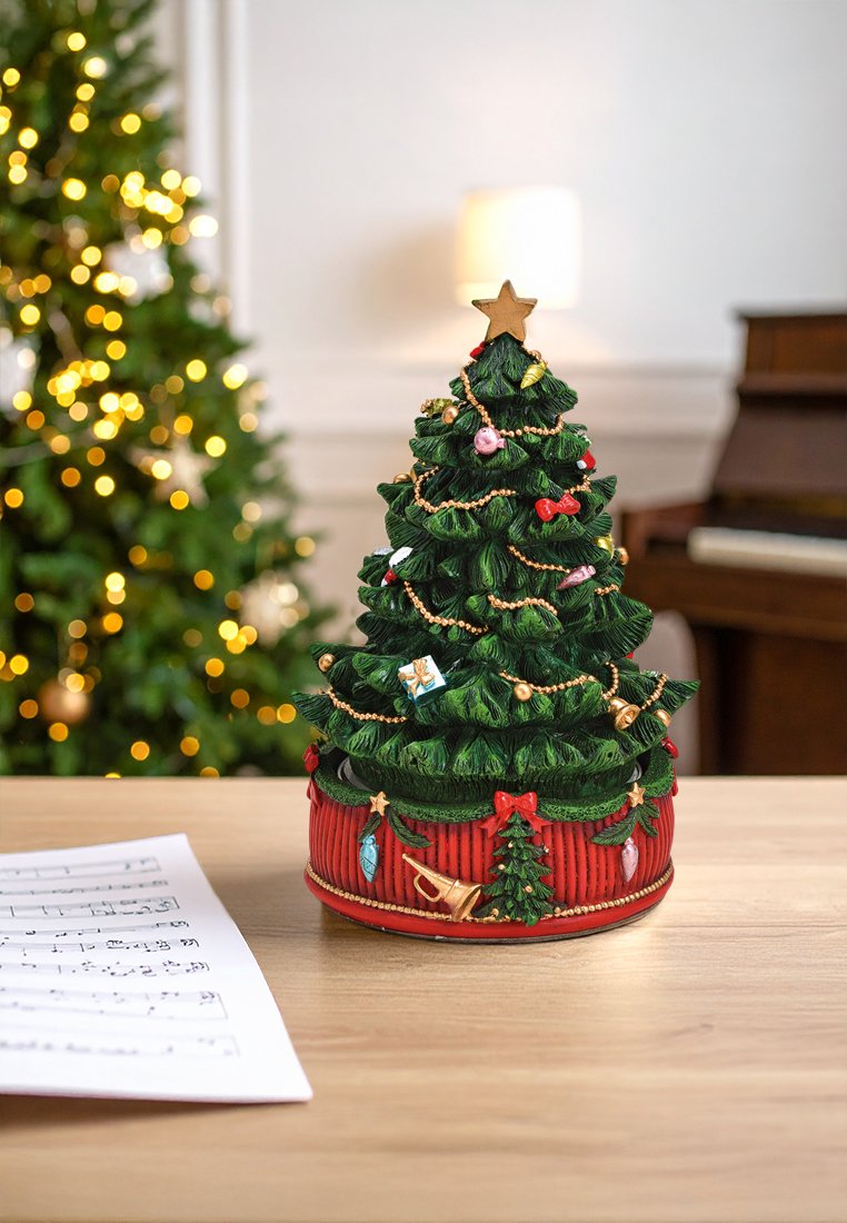 Figura decorativa di un albero di Natale, con fogliame verde e addobbi, perle dorate, sormontata da una stella, posata su una base rossa con accenti festivi.