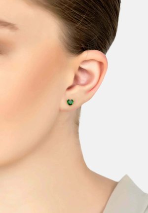 Groene hartvormige studearring, gemaakt van facetteer materiaal, met een glanzend oppervlak, bevestigd op een kleine metalen pin, gedragen op de oorlel.