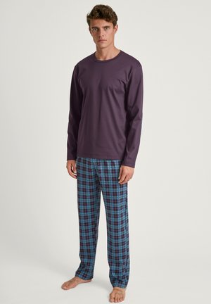 Top viola a maniche lunghe abbinato a pantaloni da pigiama a quadri blu, neri e bianchi. Tessuto morbido, vestibilità rilassata e design leggero.