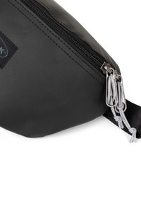 Busta nera in nylon con chiusura a zip. Presenta accessori in argento e dettagli in corda grigia. Superficie testurizzata con una leggera lucentezza.