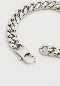 Ασημένιο μεταλλικό βραχιόλι με συνδεδεμένους κρίκους, διαθέτοντας στιβαρό κούμπωμα. Η επιφάνεια είναι γυαλισμένη με κομψό, καθρεπτιστικό φινίρισμα.