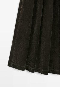 Black velvet garment with a smooth texture, featuring pleats and a straight hem. The fabric has a subtle sheen and rich depth.