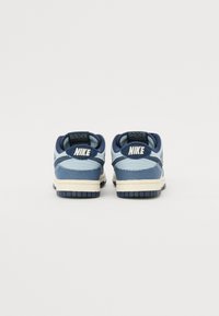 Nike Dunk Low sneakers i forskellige nuancer af blå med en tekstureret overdels i stof, kontrasterende cremefarvet mellemsål og gummisål.