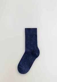 Marineblaue Socke mit geripptem Bündchen, ausgestattet mit einem strukturierten Stoff und einem kleinen lila Punktmuster. Entworfen für Komfort und passgenauen Sitz.
