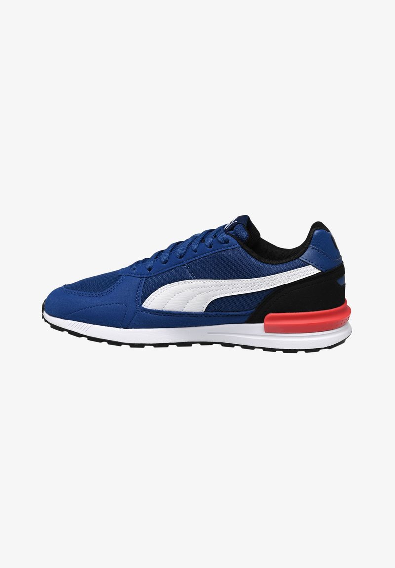 Baskets de sport bleues avec une tige texturée, des accents blancs, des détails noirs et un clip de talon rouge sur une semelle intermédiaire blanche et une semelle extérieure noire.