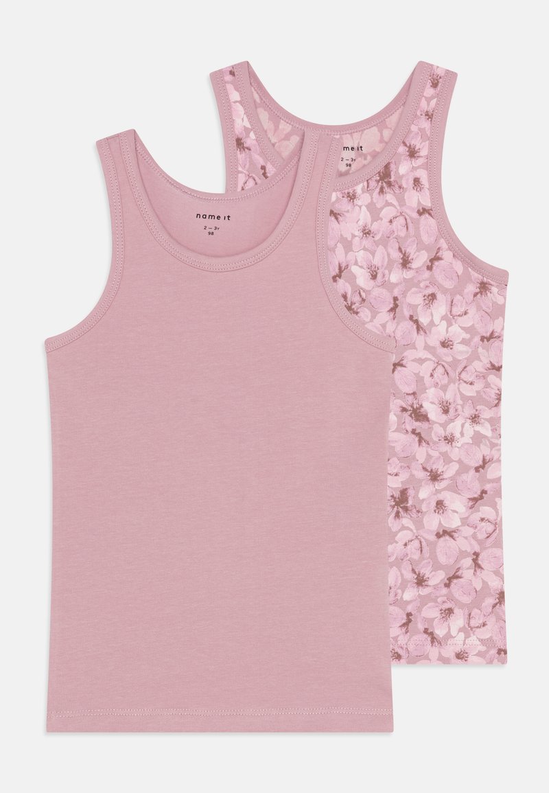 Duas camisetas de algodão cor-de-rosa: uma de cor sólida e outra com um padrão floral, apresentando alças largas e uma bainha costurada.