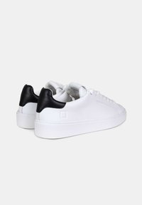 Sneaker bianche in pelle con suola piatta, caratterizzate da un accentuazione in pelle nera sul tallone e dettagli texturizzati sui lati.