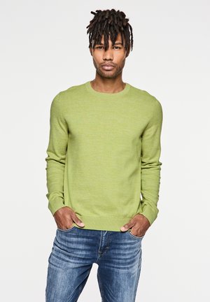 Light green knitted sweater with a round neckline, long sleeves, and ribbed cuffs, paired with blue denim jeans. Simple, textured design.