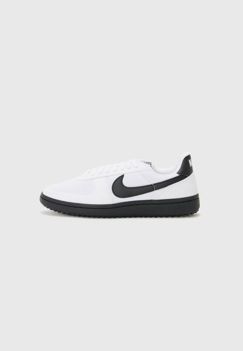 Hvide sportsko med en sort Nike swoosh, snøredesign, struktureret stofoverdel og sort gummisko.