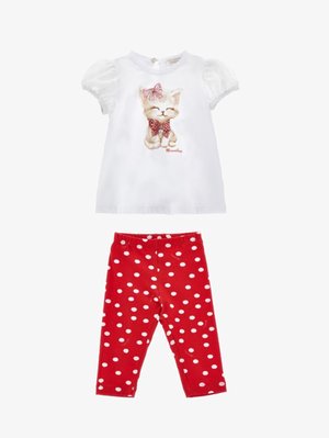 Top blanco de manga corta con un diseño de gato estampado y un lazo rosa, combinado con leggings rojos con lunares blancos. Tejido suave y estampado divertido.
