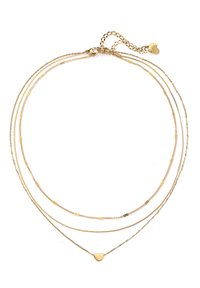 Goldfarbene mehrlagige Halskette mit drei Ketten unterschiedlicher Längen, an der untersten Kette hängt ein kleines Herzanhänger. Strukturierte Oberfläche.