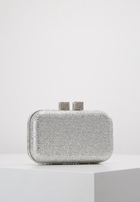Bolso de mano plateado con forma rectangular, cubierto de brillantes strass. Dos cierres metálicos cuadrados en la parte superior. Textura suave en todo el bolso.
