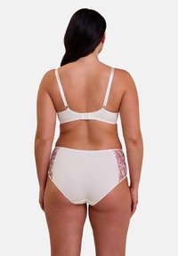 Ensemble de lingerie blanche comprenant un soutien-gorge à bretelles réglables et un culotte taille haute assortie, décoré d'accents floraux sur les côtés.