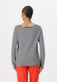 Stripet langermet topp med vid halsutskjæring, med svarte og hvite horisontale striper på mykt stoff. Bakvisning viser en tettsittende design.