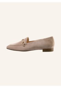 Beige suede loafers with a low stacked heel, featuring a gold-tone hardware accent and a pointed toe design. Smooth texture with minimal detailing.