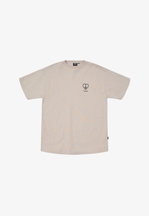 T-shirt en coton beige à manches courtes et col rond. Présente un petit logo en forme de cœur noir sur la poitrine gauche. Design à coupe droite.