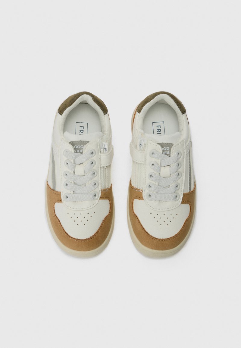 Sneakers con tomaia in pelle bianca con accenti in suede beige, punta rotonda, design perforato e doppia fascia in velcro per una vestibilità sicura.