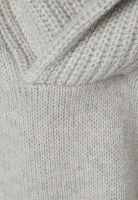 Tissu de pull tricoté gris clair avec une surface douce et texturée, présentant un col drapé et des points serrés.