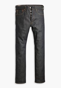 Jean denim indigo foncé à jambes droites, braguette à boutons, cinq poches et coutures contrastées, posé à plat sur un fond blanc.