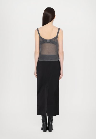 Zwarte, enkel-lange rok gecombineerd met een grijze, doorschijnende camisole-top met dunne bandjes en een textuur in gebreid ontwerp.