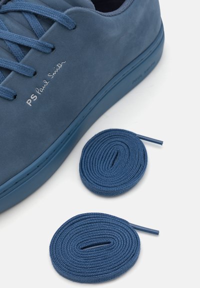 Kék velúr sportcipő passzoló fűzővel, lapos kialakítás, texturált felsőrész, és "PS Paul Smith" logo az oldalán. A fűzők csavart és kerek formájúak.