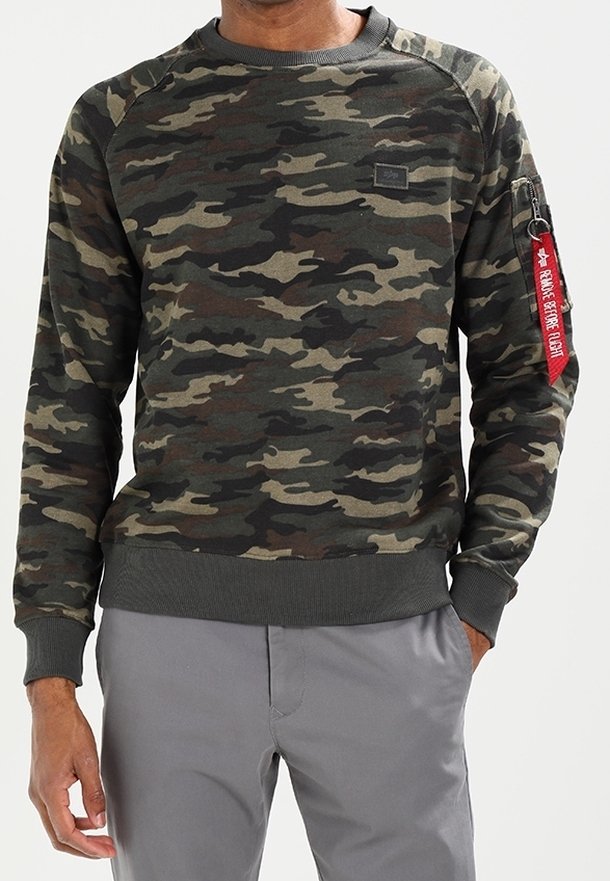 Felpa con motivo camouflage nei toni del verde scuro, marrone e nero, con polsini e orlo a costine. Presenta una tasca con zip sulla manica con un tirante rosso.