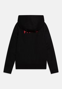 Felpa nera con finitura testurizzata, caratterizzata da una grafica rossa "FACE" prominente sul retro. Completa di cappuccio con cordino e dettagli a costine sui polsini.