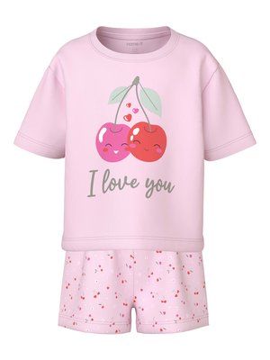 Lyserød kortærmet børnetop med smilende kirsebær og teksten "Jeg elsker dig", kombineret med lyserøde shorts med små kirsebær- og blomsterprint.