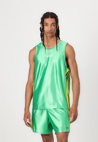 Tricou de sport verde din satin, cu dungi laterale galbene și logo-ul alb adidas, asortat cu pantaloni scurți verzi, care au un accent roșu adidas.