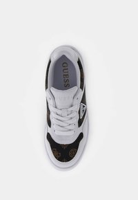 Sneaker bianco e nero con tomaia a patterned, caratterizzata da intricate decorazioni dorate, lacci bianchi e suola in gomma. Logo sul lato.
