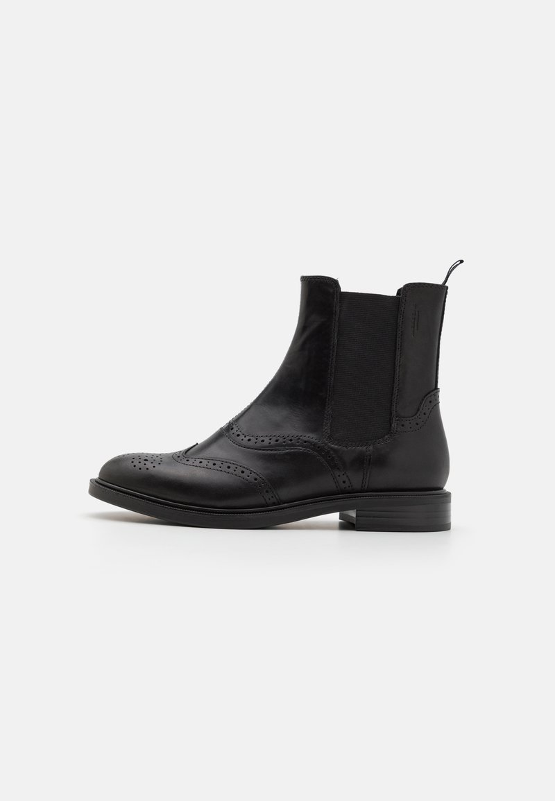 Mustad mustad nahast pahkluudega saapad, millel on elastsed külgpanelid, brogue detailid, ümar varvas ja madal virnastatud konts.