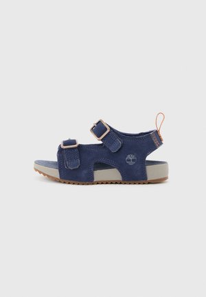 Children’s navy blue open-toe sandal with two adjustable straps, beige sole, textured bottom, and orange pull tab at heel.