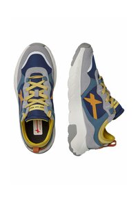 Scarpe da ginnastica navy e grigie con accenti e lacci gialli. Presentano una robusta suola in gomma, un collare imbottito e un marchio visibile.