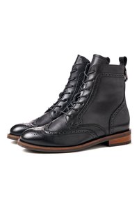 Czarne skórzane botki za kostkę z detalami w stylu brogue, zapinane na sznurowadła, z okrągłym noskiem i kontrastującą drewnianą podeszwą. Posiadają pętelkę z tyłu.