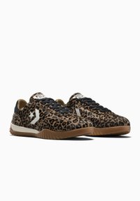 Pereche de pantofi sport tip low-top cu imprimeu leopard, șireturi negre, logo alb pe lateral și tălpi din cauciuc maro, pe un fundal alb.
