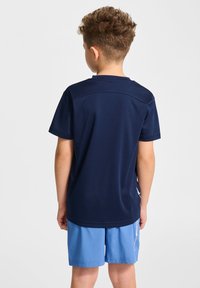 T-shirt de sport bleu marine à manches courtes avec un col rond, en tissu texturé, et des accents blancs contrastants sur les côtés.