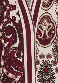 Textil med bourgogne, krämfärgade och bruna mönster. Innehåller paisleymönster, kurviga motiv och djärva ränder. Slät textur, lättviktsmaterial.